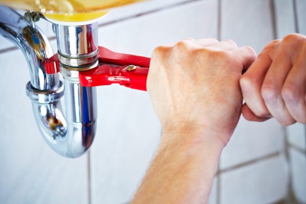 plumber-hands-holding-wrench-and-fixing-a-sink-in-bathroom-picture-id155432541